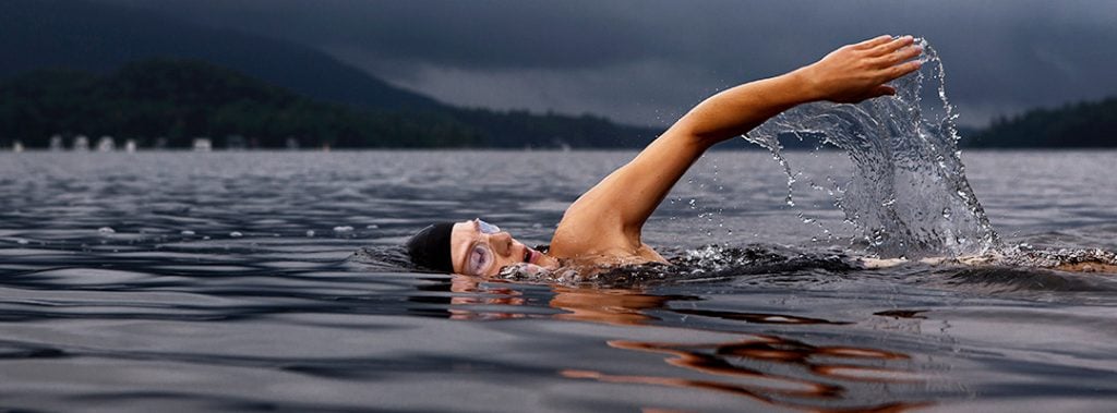 a woman has one arm out of the water while swimming